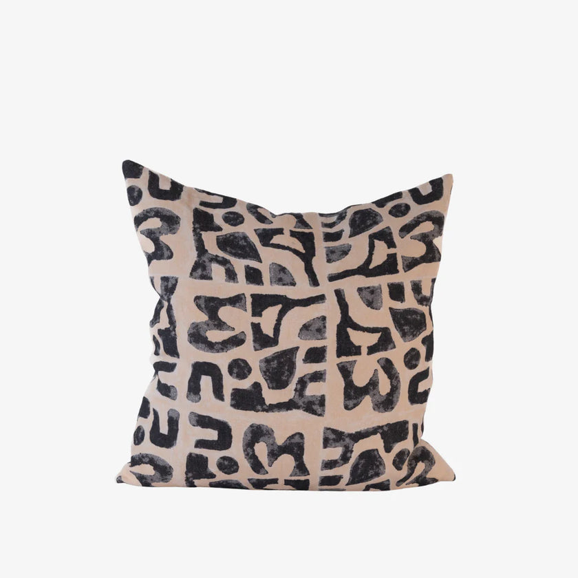 Abstract black print cushion on nude linen, square decorative cushion on white background