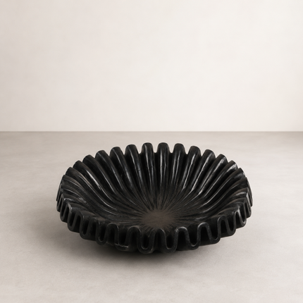 Hand-chiselled black marble bowl with deeply fluted outer walls and a smooth interior