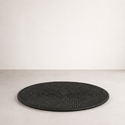 Round rattan placemat in black, the weave spiralling out from a single centre point