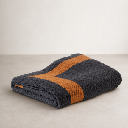 Drift throw folded to show a heavy charcoal knit crossed by a mustard band