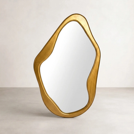 Gold organic-shaped wall mirror, front view on neutral background