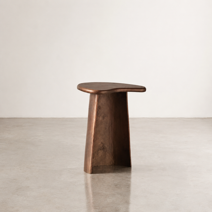 Rockpool side table with a freeform top in deep oil brass on a tapered pedestal