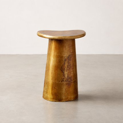 Rockpool side table with a freeform top in mottled vintage brass on a tapered pedestal
