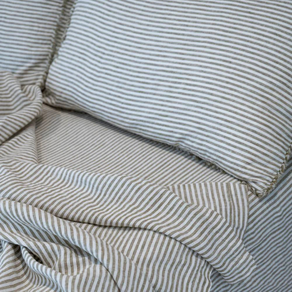 Rumpled pencil-stripe French linen bedding, fine woven stripes over a pale ground