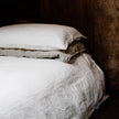 Coastalis Living + Design French Linen Bedding in Off White Natural Stripe styled on bed with timber headboard