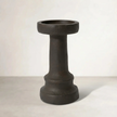 a cement candle holder in black and natural