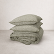 French flax linen quilt cover in olive pencil stripe, folded with matching pillowcases