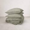 French flax linen quilt cover in olive pencil stripe, folded with matching pillowcases