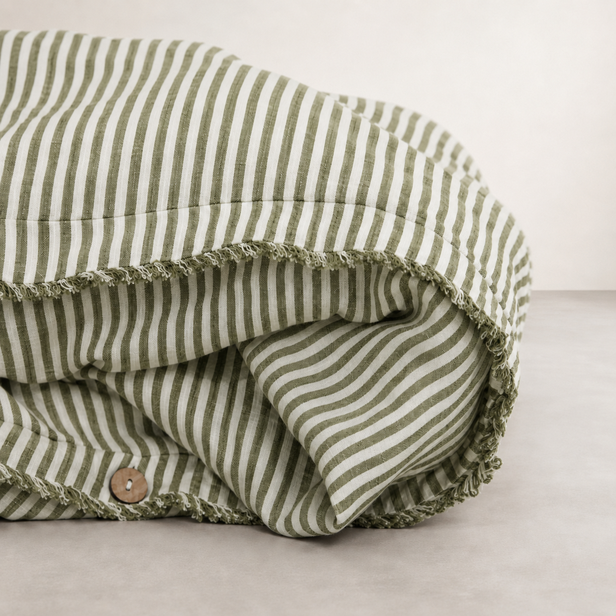 Olive pencil stripe linen quilt cover folded to show the button closure along the edge