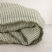 Olive pencil stripe linen quilt cover folded to show the button closure along the edge