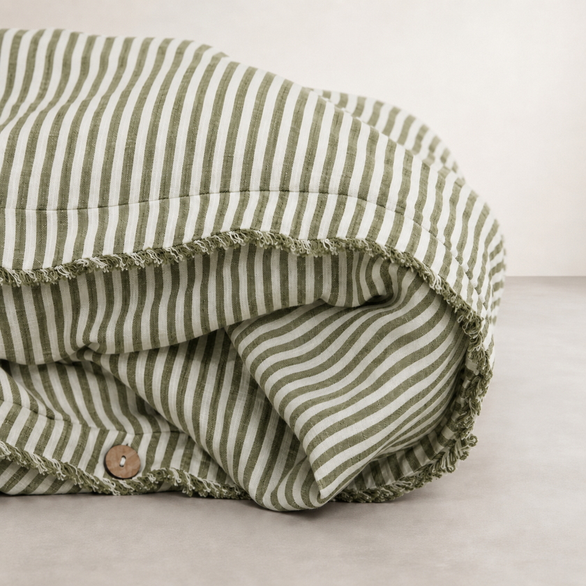 Olive pencil stripe linen quilt cover folded to show the button closure along the edge