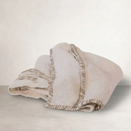 Coastalis Living + Design Zayra Table Cloth in Natural, folded with fringed edge detail