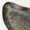 Close view of a Tova plate, reactive glaze pooling in moss and latte over espresso